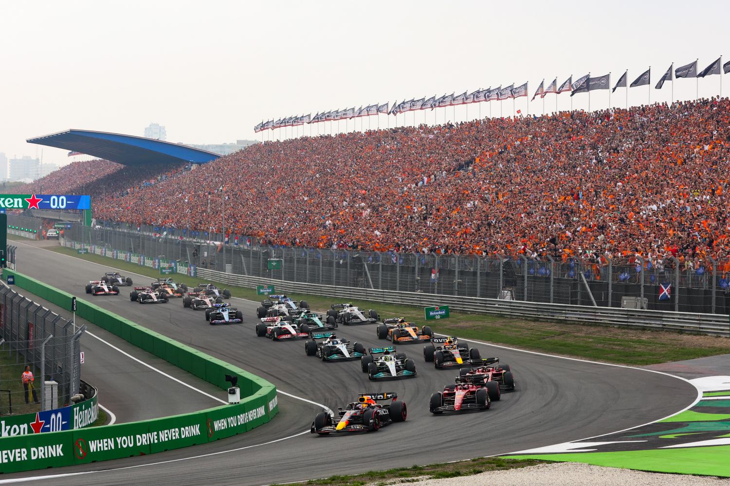 Formula 1 cars racing in front of a packed grandstand